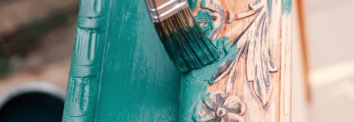 Pinsel trägt grüne Farbe auf Holz auf